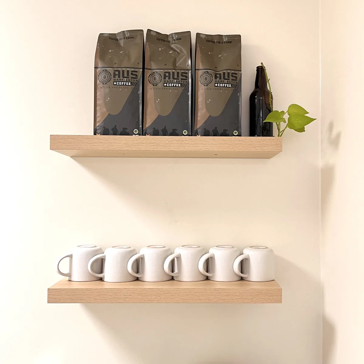 Bags of Australian Warfighters Coffee and a row of mugs on timber wall shelves